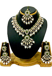 Magnificent necklace set designed in a very unique approach for wedding purpose. A drop shape diamond pendant and whole necklace studded with diamonds with hanging white moti in parallel with green beads. A pair of matching earrings and maangtika include with this necklace. Keep away from water, sweat and perfume. Slight Color variations are possible due to differing screen and photograph resolution.